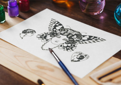 Traditional butterfly tattoo design print on table with watercolor paints