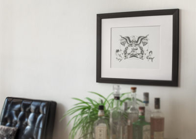 Traditional American Eagle tattoo flash with ship and mermaids hung and framed on a wall